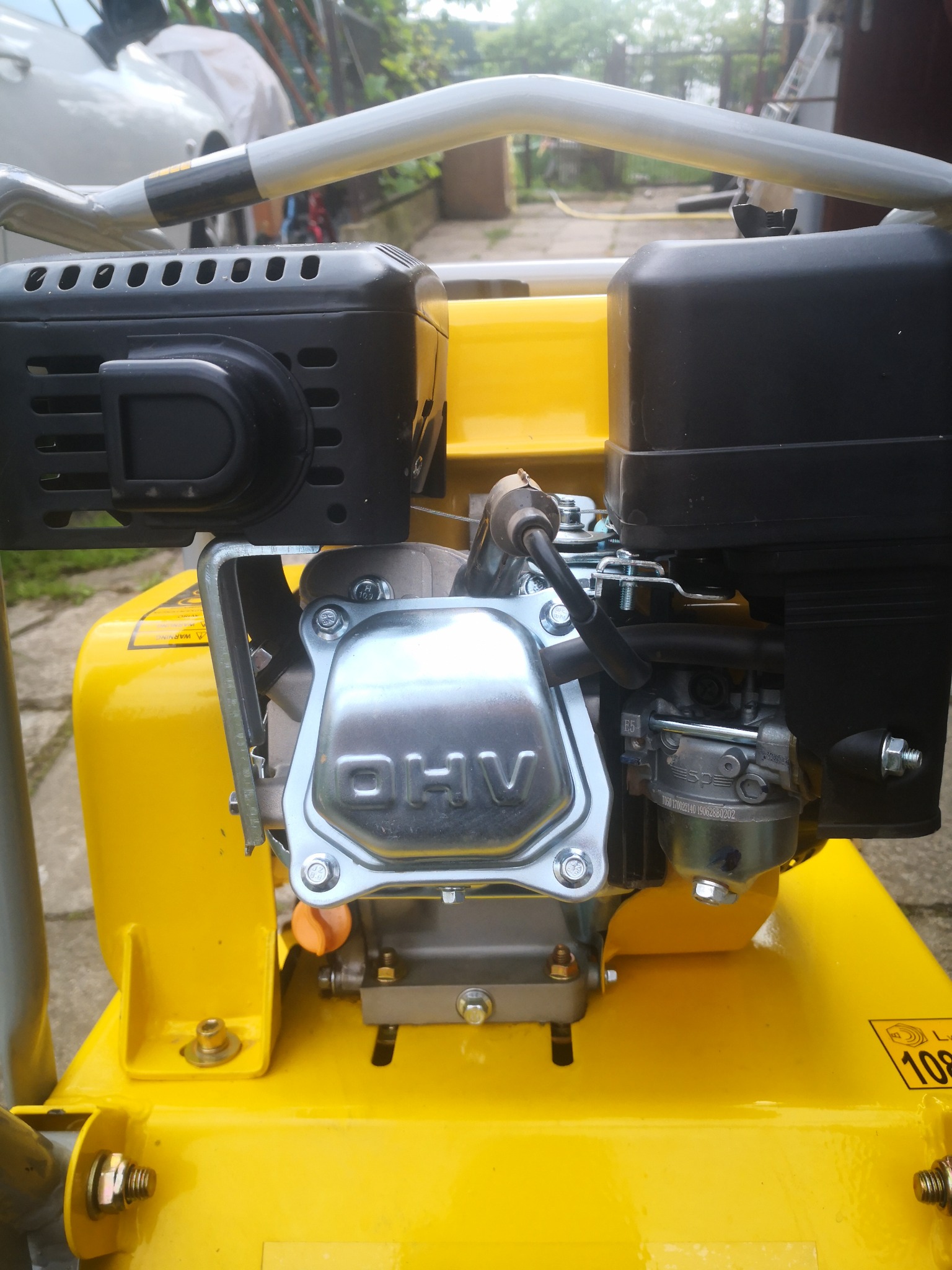 Żółta zagęszczarka gruntu z silnikiem spalinowym OHV, widoczne detale konstrukcyjne i oznaczenia producenta.