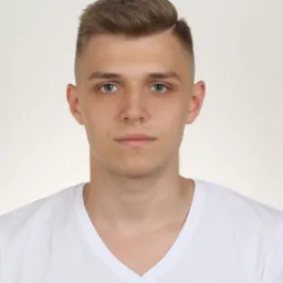 Portret młodego mężczyzny z krótkimi, brązowymi włosami zaczesanymi na bok, ubrany w biały T-shirt z dekoltem w serek, na jasnym tle.