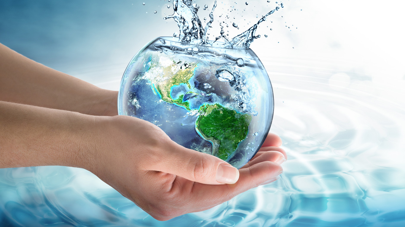 Dłonie trzymają szklaną kulę z mapą świata wypełnioną wodą, z której wylewają się krople.