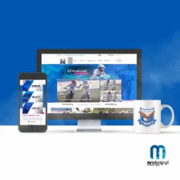 Prezentacja strony internetowej klubu żużlowego KŻ Orzeł Łódź na monitorze i telefonie, obok kubek z logo klubu i logo firmy mrsdesign.pl na białym tle z błękitnymi akcentami.