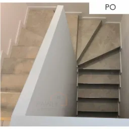 Schody zabiegowe obłożone gresem i białą listwą przypodłogową.