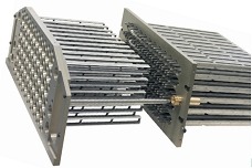 Dwie metalowe płyty z precyzyjnie wywierconymi otworami i wystającymi prętami, połączone elementem z mosiądzu, na białym tle.