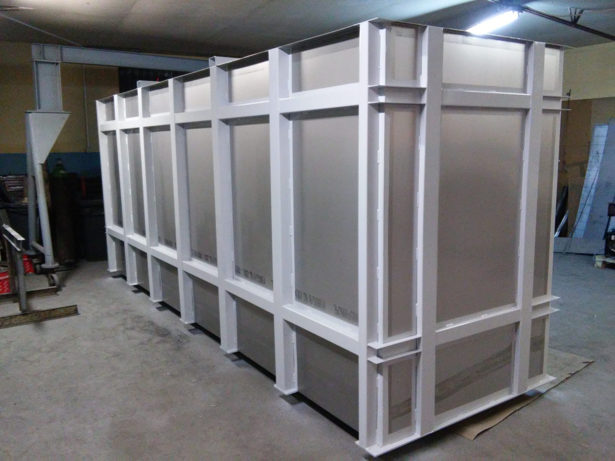 Duża, pomalowana na biało konstrukcja stalowa z panelami, prawdopodobnie fragment większej hali, widoczna w hali produkcyjnej.