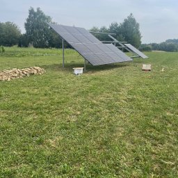 LDR Electrical Dariusz Karaś - Instalacja paneli fotowoltaicznych na łące w Sobniowie, widoczne dwa rzędy paneli, stos ziemi i skrzynka narzędziowa.
