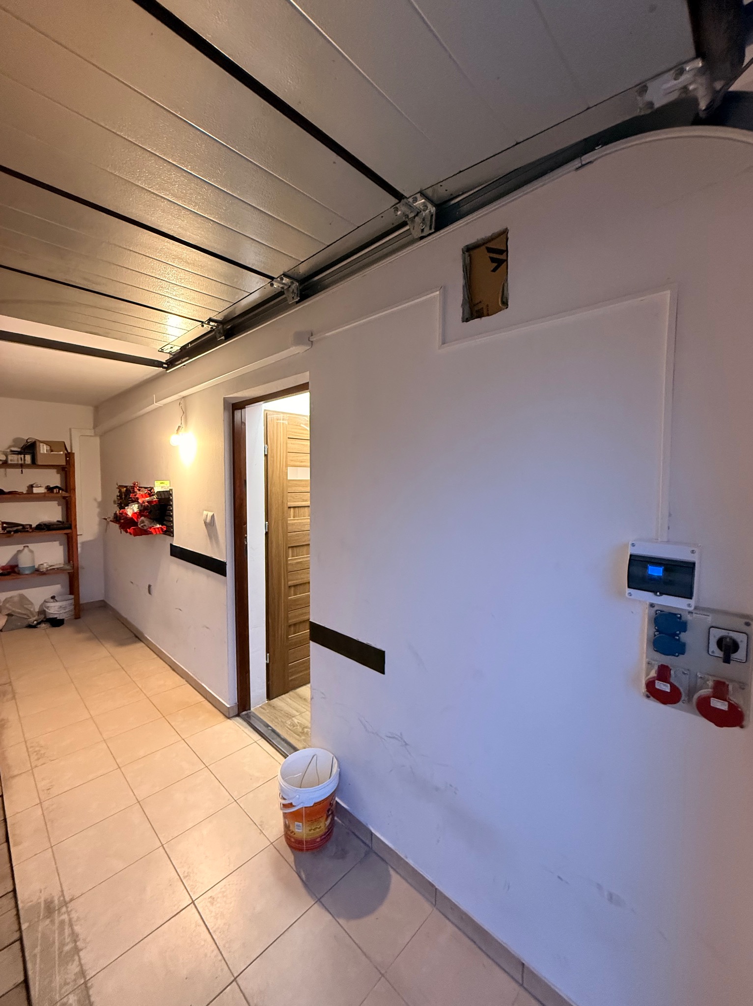 Gniazda siłowe i skrzynka elektryczna na ścianie w garażu w Jaśle. Widoczne przewody i instalacja elektryczna. Prace wykończeniowe.