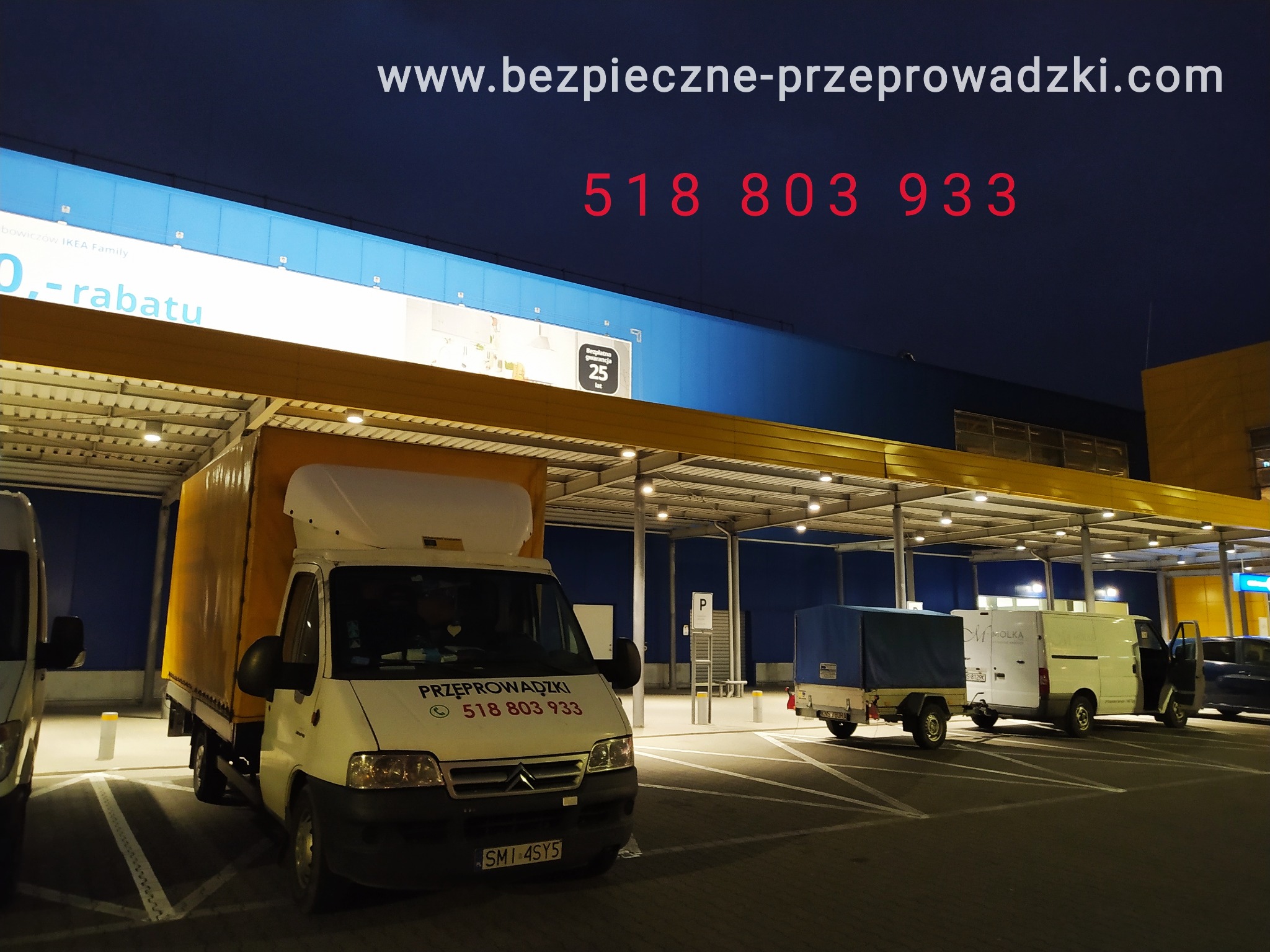 Żółty samochód dostawczy z napisem 'Przeprowadzki' i numerem telefonu zaparkowany pod zadaszeniem parkingu sklepu IKEA, widoczny również biały van i przyczepka.