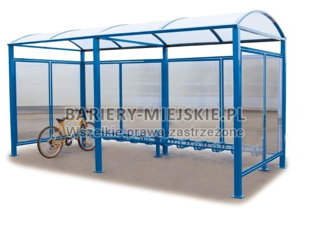 Niebieska wiata rowerowa z przezroczystymi ściankami bocznymi, zaparkowany rower z żółtą ramą po lewej stronie.