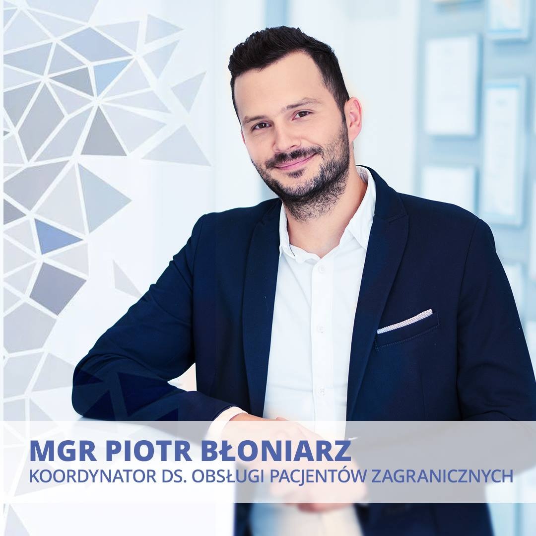 Portret uśmiechniętego mężczyzny w ciemnej marynarce i białej koszuli, z brodą, na tle jasnego biura z geometrycznym wzorem na ścianie i dokumentami w ramkach, podpisany jako mgr Piotr Błoniarz...