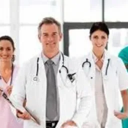 Zespół lekarzy i pielęgniarek w Wałbrzychu, uśmiechnięci i gotowi do pracy, z widocznymi stetoskopami i fartuchami medycznymi na tle jasnego, rozświetlonego wnętrza placówki medycznej.