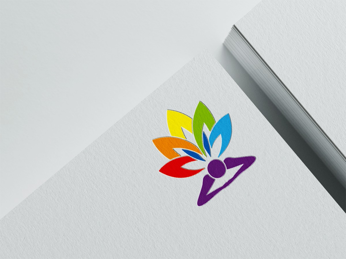 Logo z motywem kwiatu w kolorach tęczy i fioletową sylwetką osoby w pozycji jogi, umieszczone na białym, teksturowanym papierze obok stosu kartek.
