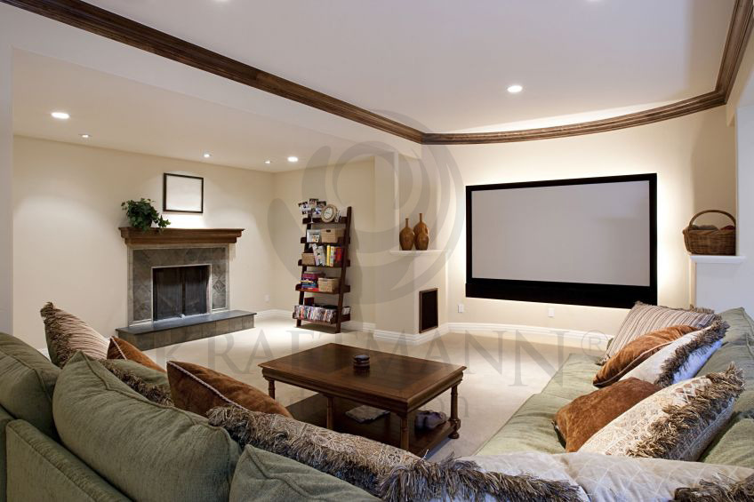 Salon z dużym ekranem projekcyjnym, oświetleniem LED pod ekranem, kominkiem i wygodną sofą.