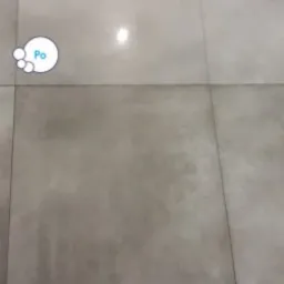 Szare płytki podłogowe przed i po czyszczeniu, z widoczną różnicą w odcieniu i połysku, zaznaczone ikonami 'Przed' i 'Po'.