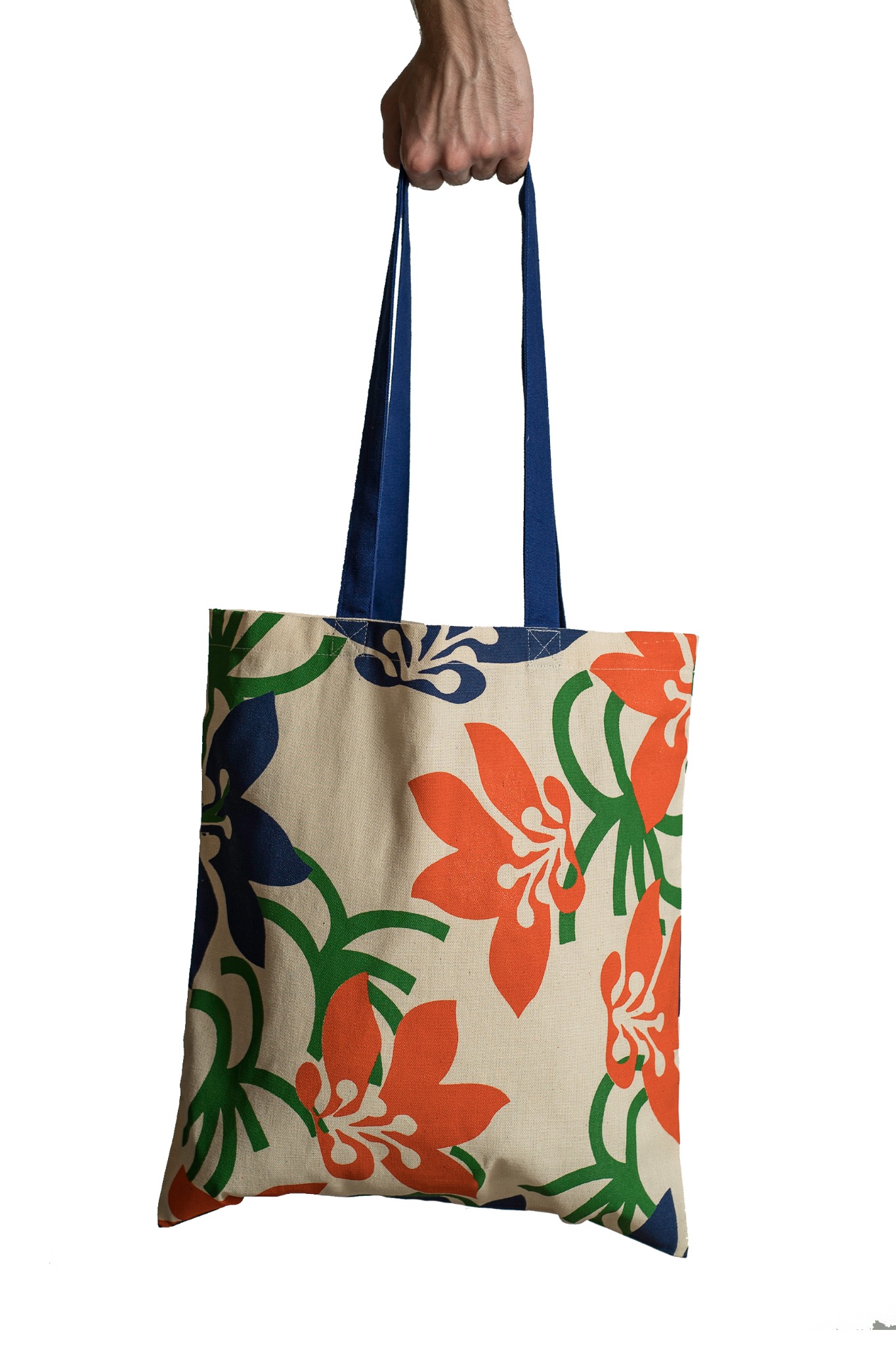 Dłoń trzymająca bawełnianą torbę na zakupy z pomarańczowo-granatowymi kwiatami na beżowym tle.