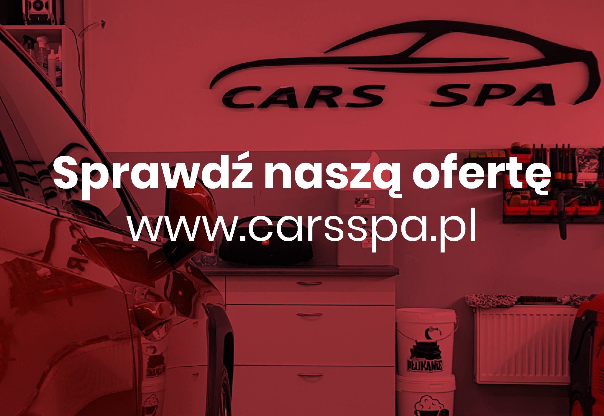 Wnętrze myjni samochodowej z logo 'Cars Spa' na ścianie, widoczne preparaty i akcesoria do pielęgnacji aut oraz fragment karoserii czerwonego samochodu.