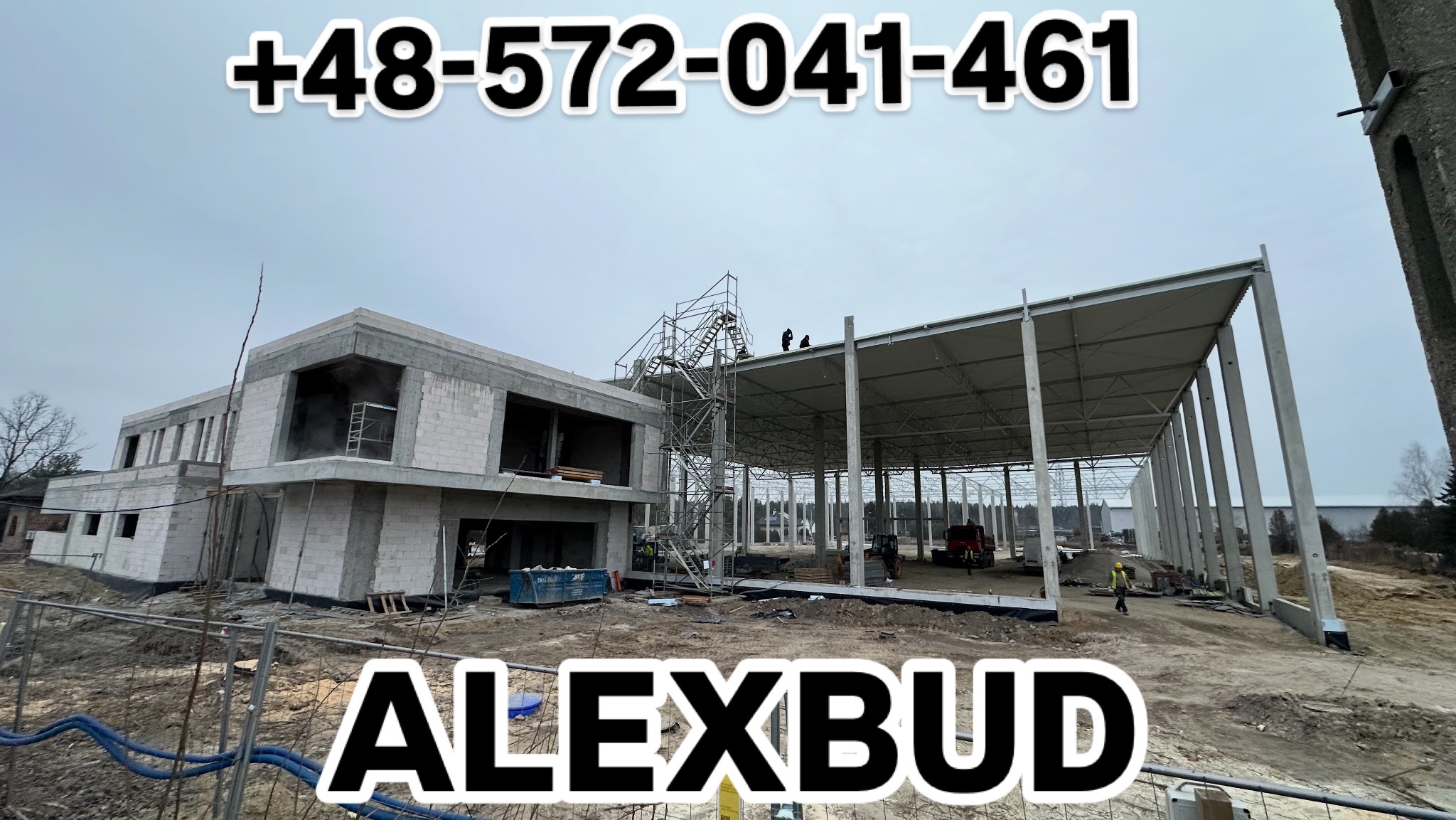 Budowa budynku z betonu komórkowego i hali stalowej z widocznymi pracownikami na rusztowaniu oraz w oddali, na zewnątrz ogrodzenia placu budowy.