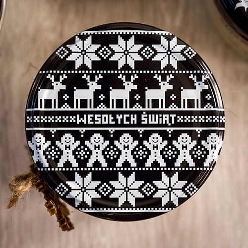 Wieczko słoika z czarno-białym, pikselowym wzorem świątecznym: renifery, śnieżynki, piernikowe ludziki i napis 'Wesołych Świąt'.