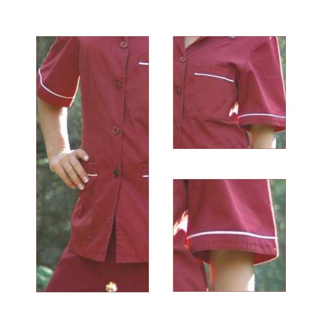 Fragmenty bordowej damskiej bluzy i spódnicy z krótkim rękawem, wykończonej białym obszyciem, prezentowane na modelu na zewnątrz.