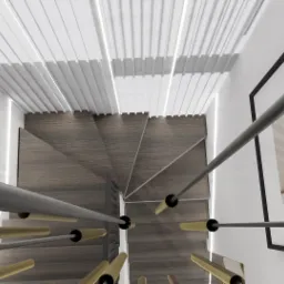 Widok z góry na spiralne drewniane schody z szarymi poręczami i złotymi elementami, oświetlenie listwowe na suficie i grafika z motywem roślinnym w czarnej ramie na ścianie.