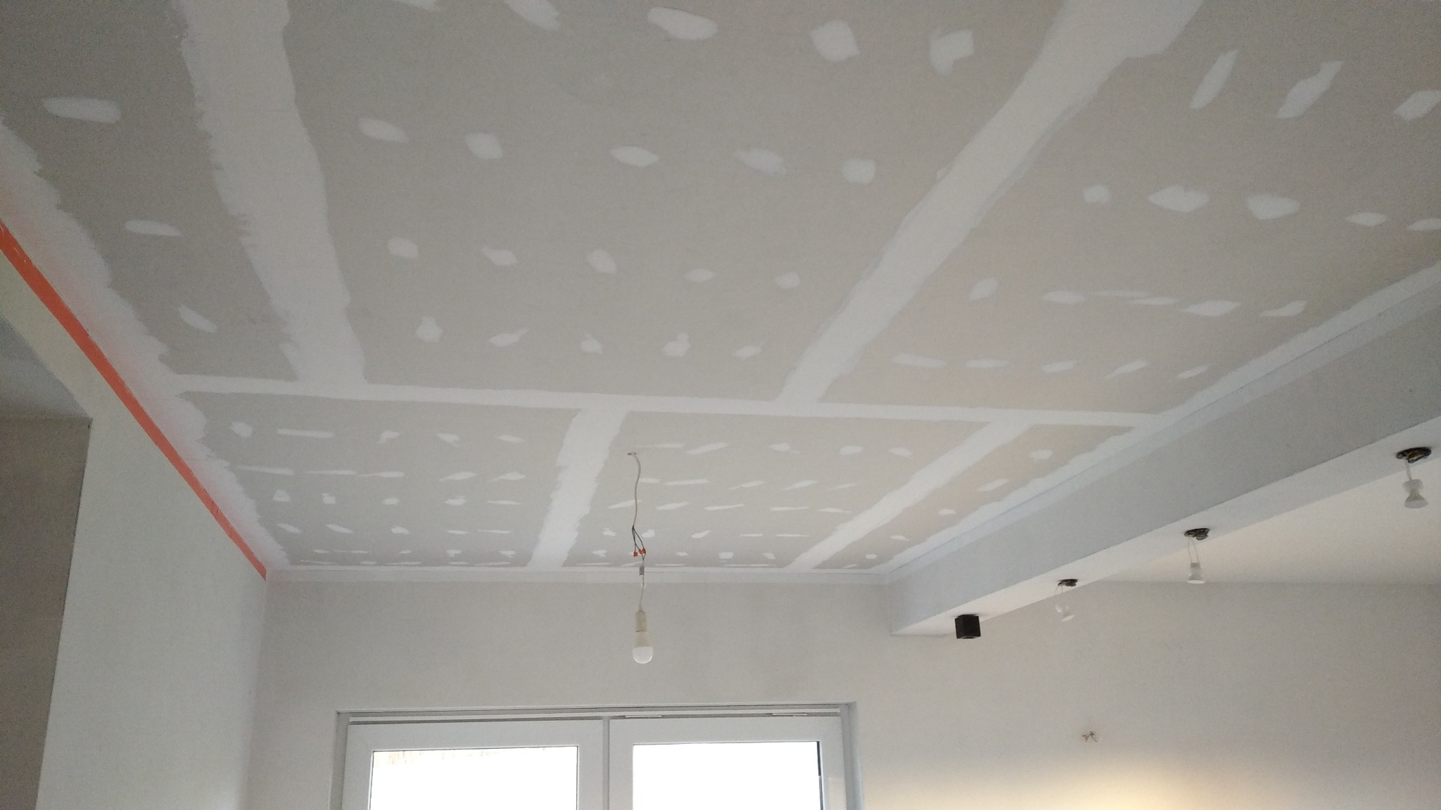 Montaż sufitu z płyty karton gips w Lubaniu, widoczne łączenia płyt i miejsca po wkrętach przygotowane do szpachlowania.