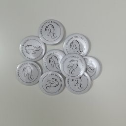 Seleo Druk - Kolekcja okrągłych przypinek z logo stajni jeździeckiej 'Stajnia Spełnione Marzenie', prezentujących stylizowaną grafikę głowy konia w czerni na białym tle.