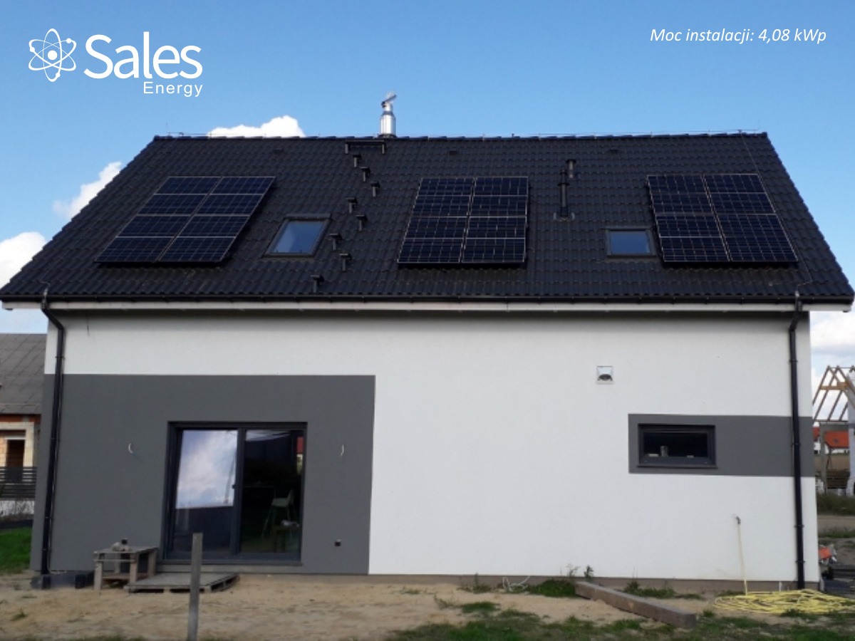 Dom jednorodzinny z zainstalowanymi panelami słonecznymi na dachu o mocy instalacji 4,08 kWp. Widoczne trzy zestawy paneli, każdy z nich umieszczony nad oknem dachowym, na czarnym dachu z dachówki.