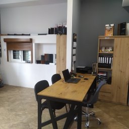 Stolar Agnieszka Pikulik - Wnętrze biura firmy oferującej stolarkę okienną i drzwiową, z ekspozycją rolety zewnętrznej, wzornikami kolorów i materiałów, biurkiem z laptopem i szafą z katalogami.