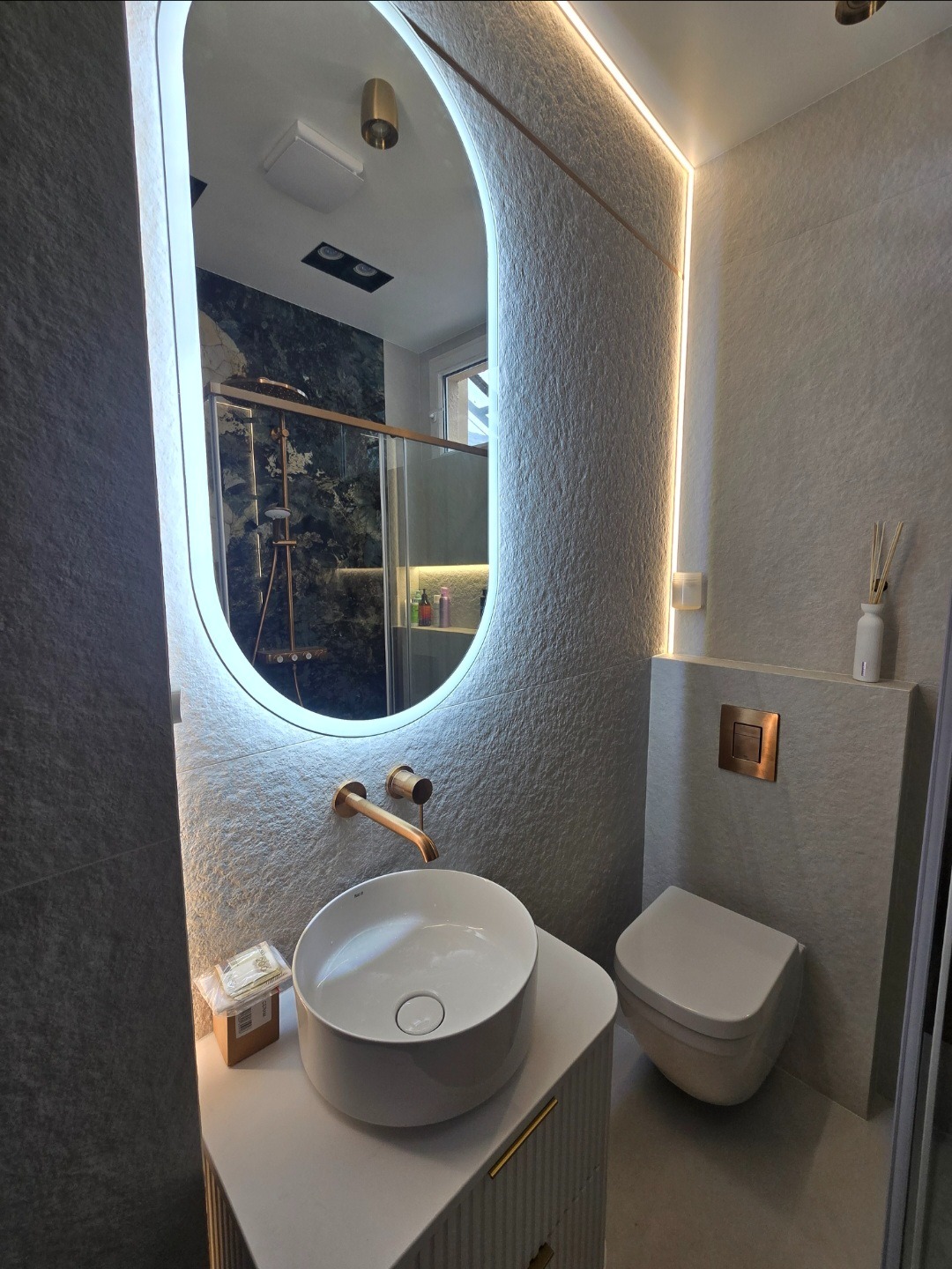 Oświetlenie LED na płytkach z wyraźną strukturą pod odpowiednim kątem całkowicie zmienia odbiór łazienki.