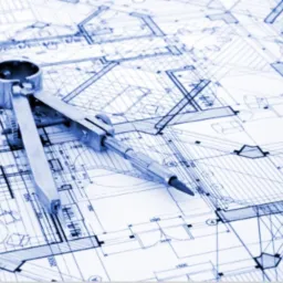 Rzut techniczny budynku z metalowym cyrklem kreślarskim, niebieska tonacja, widoczne szczegóły konstrukcyjne.