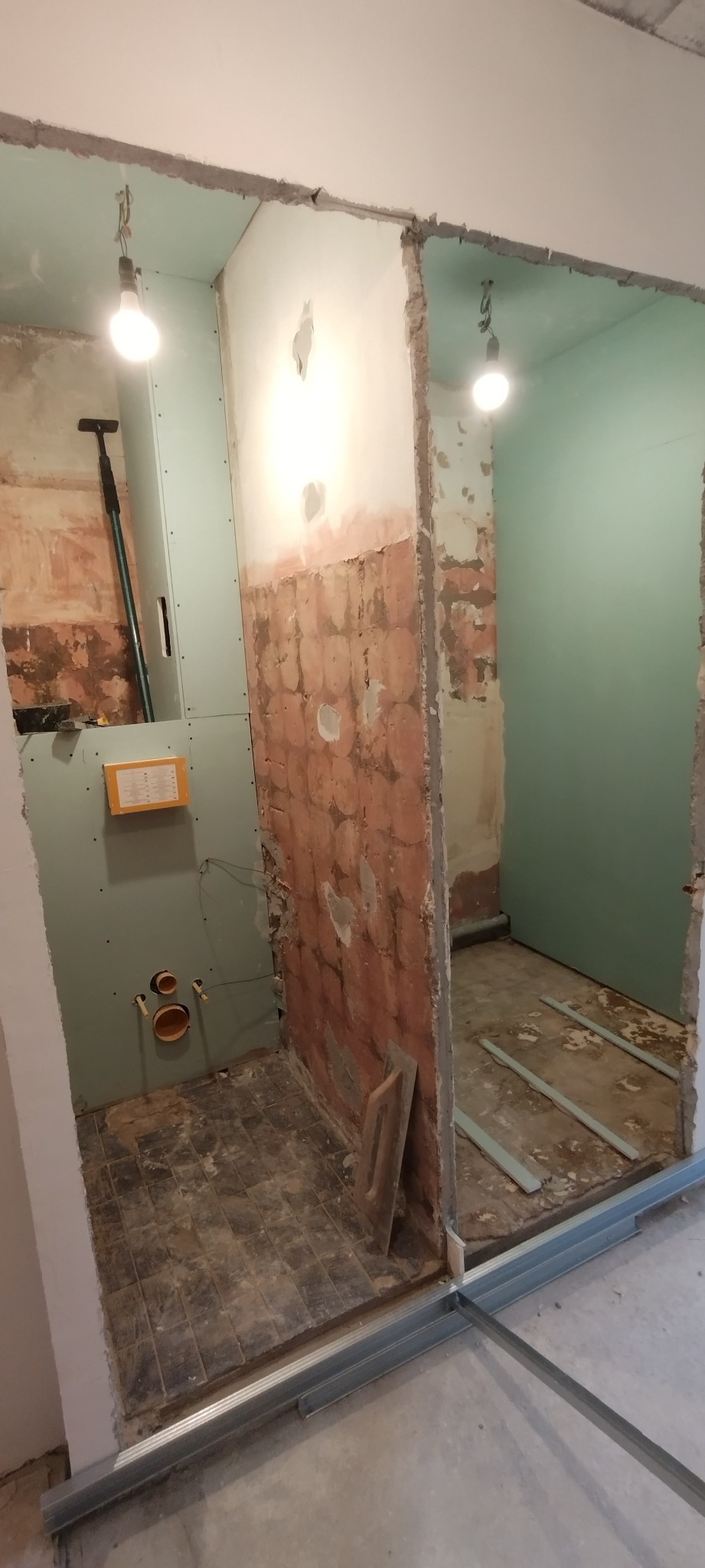 Łazienka w trakcie remontu: widoczne surowe ściany, instalacja podtynkowa, płyty gipsowo-kartonowe i metalowe profile konstrukcyjne.