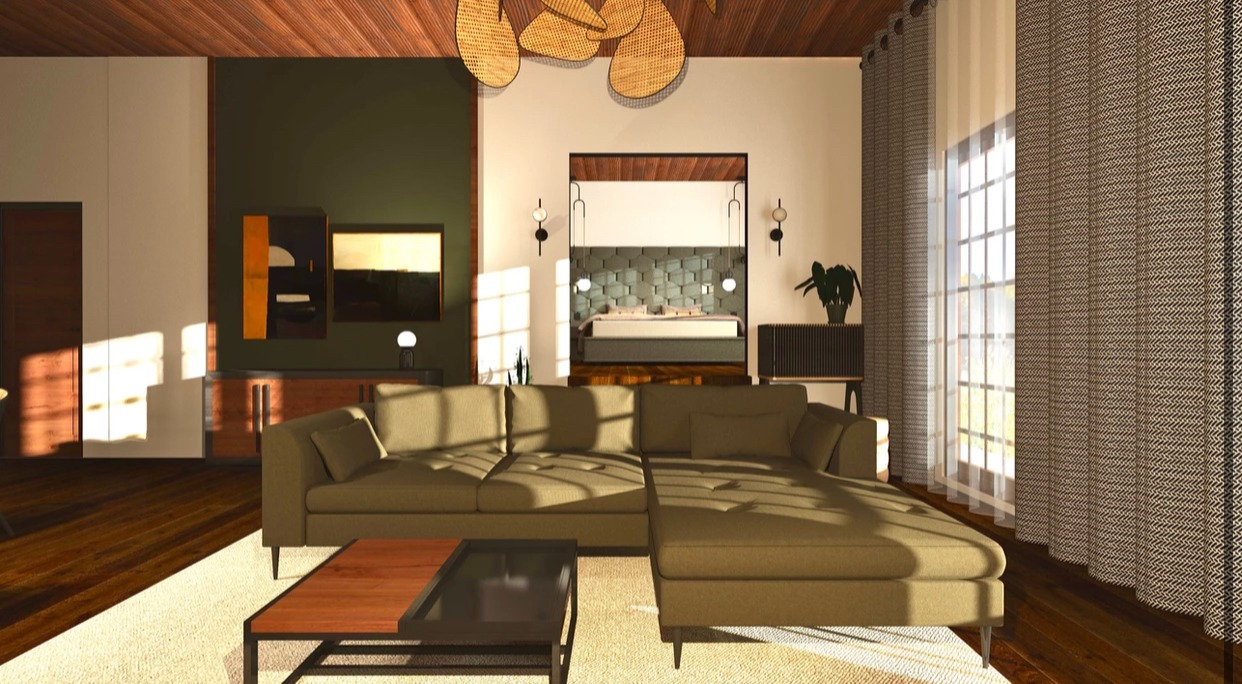 Nowoczesny salon z zieloną sofą narożną, drewnianym sufitem i widokiem na sypialnię przez otwarty portal, oświetlony popołudniowym słońcem.