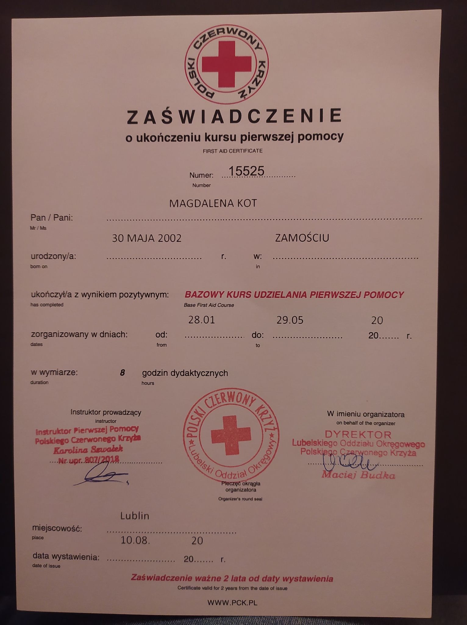 Skan zaświadczenia o ukończeniu bazowego kursu udzielania pierwszej pomocy, wydanego przez Polski Czerwony Krzyż, z pieczęciami i podpisami, z danymi osobowymi Magdaleny Kot i datami odbycia kursu.