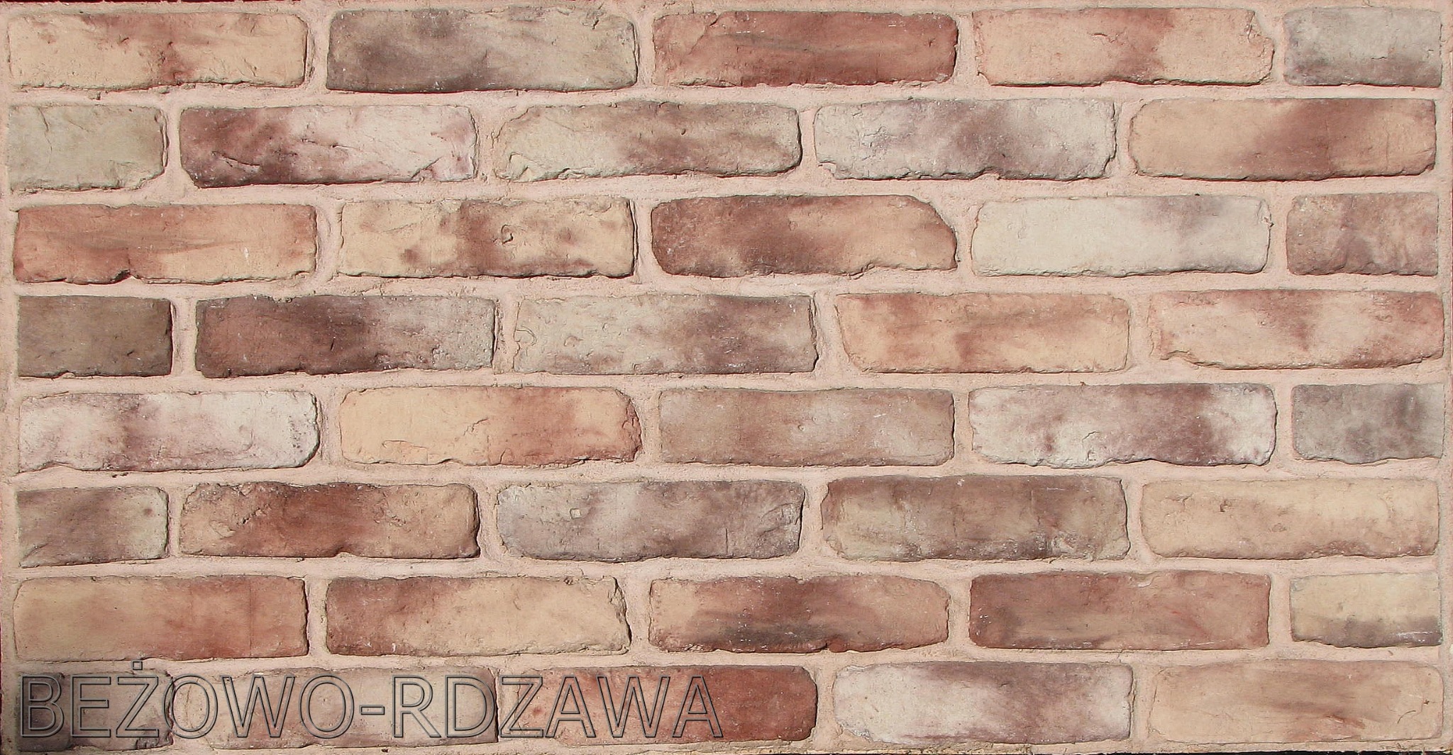 Fragment ściany z beżowo-rdzawych cegieł licowych o nieregularnej fakturze, z widocznym napisem 'BEŻOWO-RDZAWA' w dolnej części.