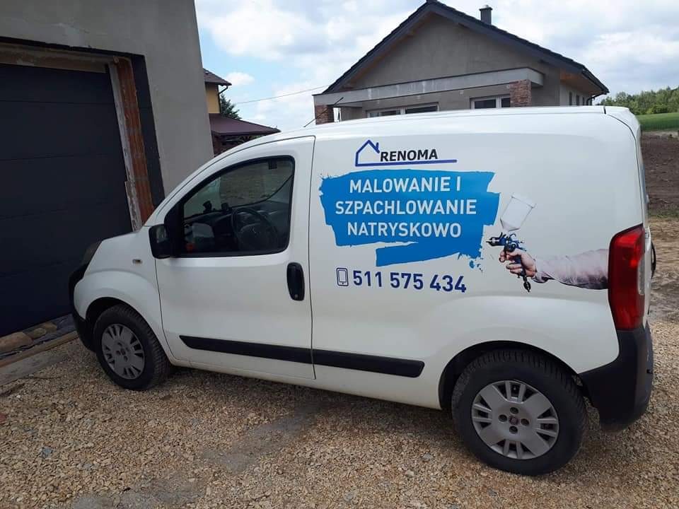 Biała furgonetka z reklamą firmy Renoma oferującej malowanie i szpachlowanie natryskowe, zaparkowana na żwirowym podjeździe przed domem.