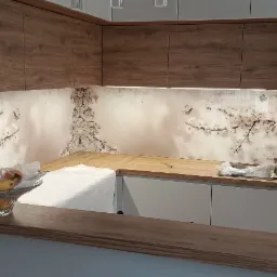 Szklana ściana w kuchni z motywem kwitnącej wiśni i motyli, brązowe szafki wiszące, blat z jasnego drewna, owoce w koszyku na pierwszym planie.