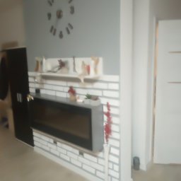 Patbud - Nowoczesny salon z dekoracyjną ścianą z białej cegły, na której wisi czarny kominek elektryczny. Na ścianie zegar i półka z ozdobami. W tle drzwi i szafa.