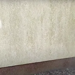 Czyszczenie elewacji budynku z widocznymi zaciekami i zabrudzeniami przy użyciu myjki ciśnieniowej, fragment ściany już oczyszczony.