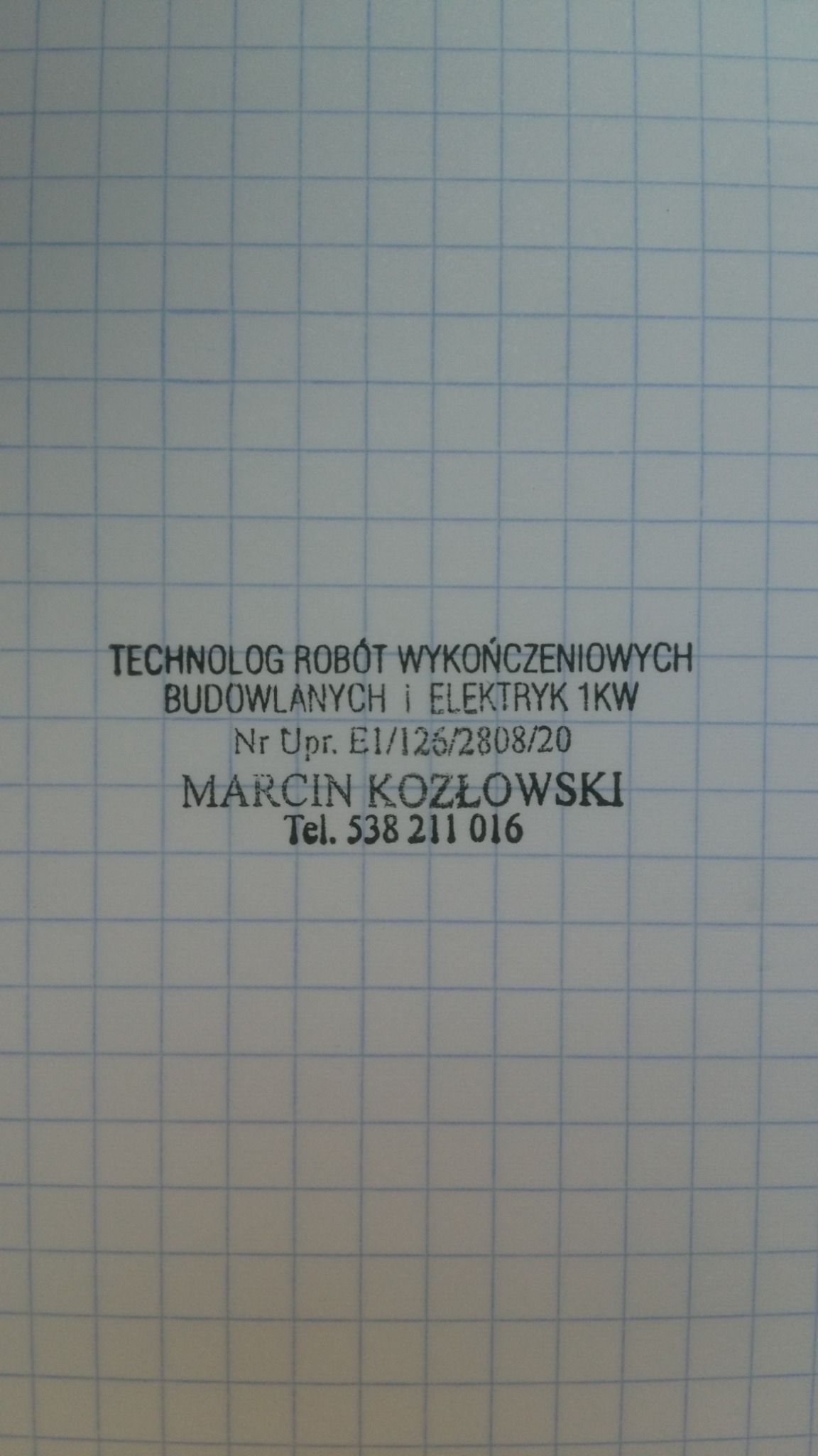 Kadr z bliska na kartkę w kratkę z pieczątką firmy: TECHNOLOG ROBÓT WYKOŃCZENIOWYCH BUDOWLANYCH i ELEKTRYK 1KW, Nr Upr. E1/126/2808/20, Marcin Kozłowski, Tel. 538 211 016.