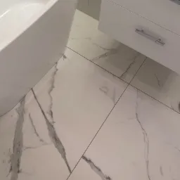 Biała łazienka z wanną wolnostojącą i szafką pod umywalkę, płytki podłogowe imitujące marmur Calacatta