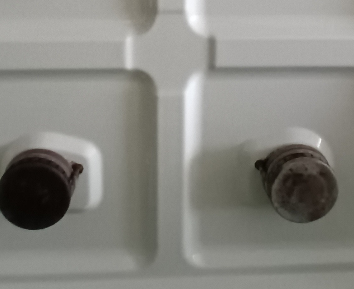 Bliski kadr odpływów w zlewie z widocznymi śladami użytkowania i zaciekami.