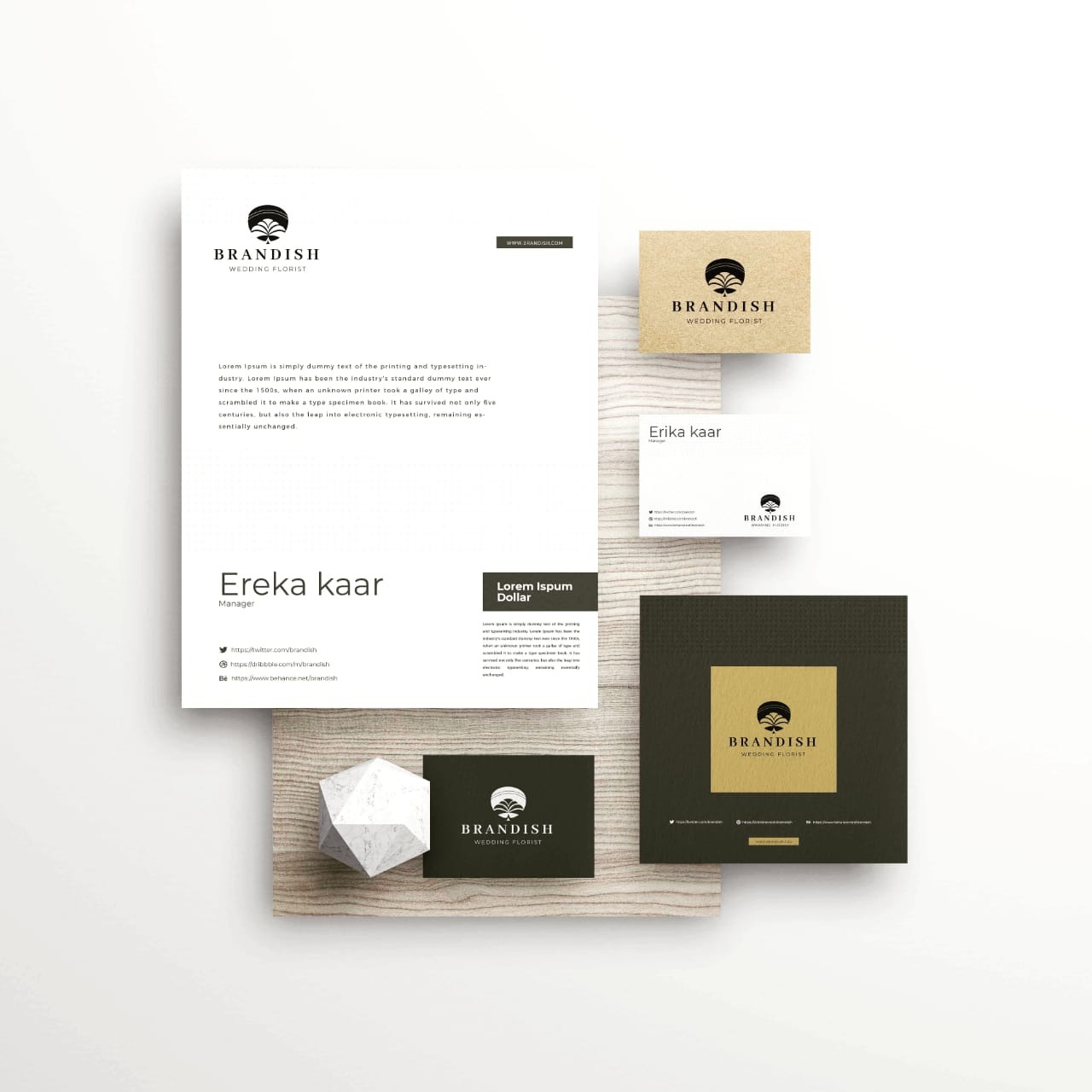 Elegancki zestaw materiałów firmowych z logo 'Brandish Wedding Florist' na białym papierze firmowym, wizytówkach i kartach prezentacyjnych, ułożony na drewnianym tle z geometryczną ozdobą.
