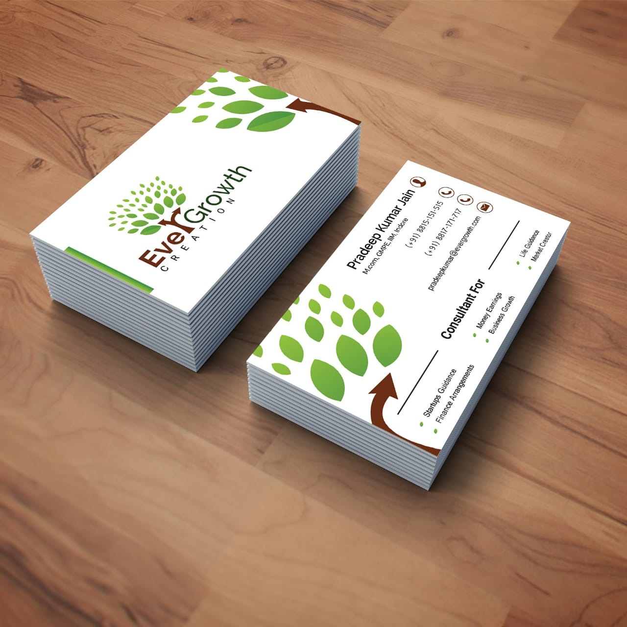 Wizualizacja dwóch stosów wizytówek firmy z Tarnowa, z motywem drzewa z zielonych liści i brązowym pniem, na drewnianym tle.