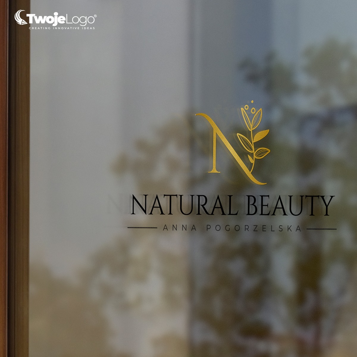 Złoty logotyp 'Natural Beauty' z motywem kwiatowym i inicjałem 'N', umieszczony na szklanej powierzchni z widocznym rozmytym tłem.