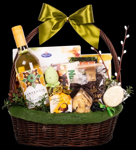 Wielkanocny kosz wiklinowy wypełniony winem Arpeggio, czekoladkami, kawą ziarnistą, suszonymi bananami i ozdobami w postaci jajek i bazi.