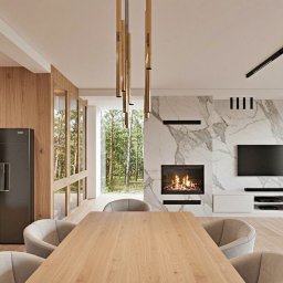 MG Studio Projektowania Wnętrz - Nowoczesna jadalnia z drewnianym stołem, marmurowym kominkiem i czarną lodówką. Minimalistyczne oświetlenie i duże okna z widokiem na zieleń.