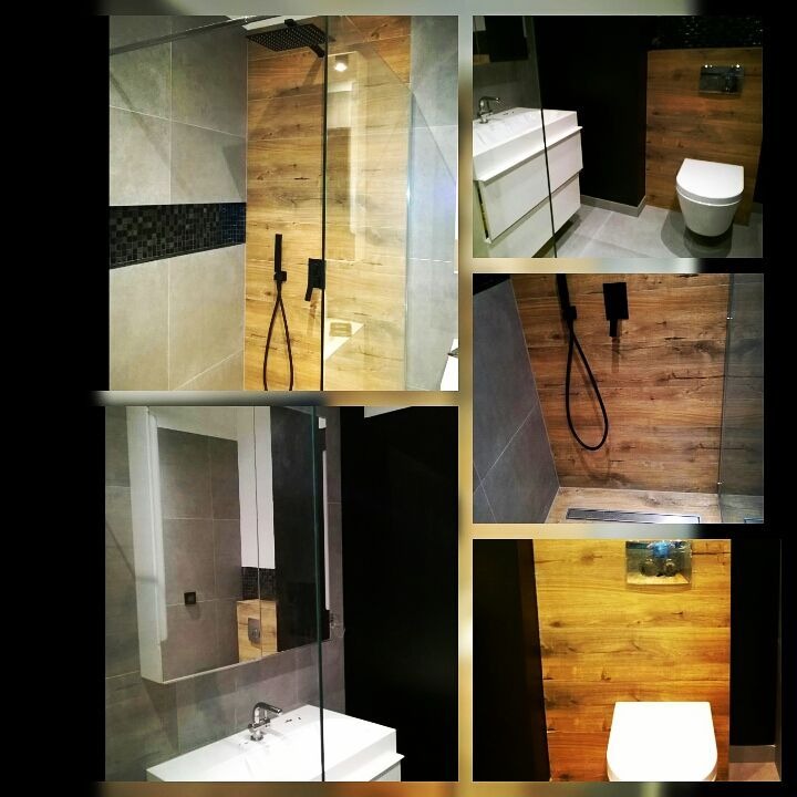 Nowoczesna łazienka z elementami drewna: kabina prysznicowa typu walk-in z czarną armaturą, umywalka z szafką, toaleta podwieszana, szare płytki i dekoracyjny pas mozaiki.