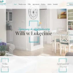 Zrzut ekranu strony internetowej Turkusowa Ostoja, prezentujący wnętrze willi nad morzem w Łukęcinie. Widoczny salon z szarą kanapą, kwiatami, białym stołem jadalnym i krzesłami, oraz elementami...