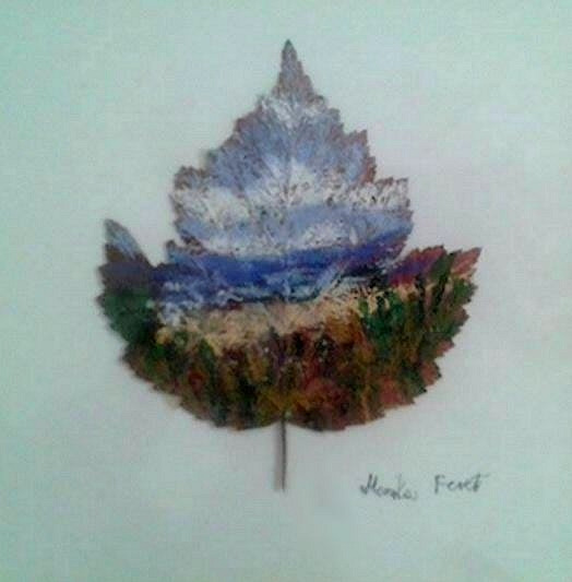 Pejzaż górski namalowany na uschniętym liściu, z widocznym podpisem artysty w prawym dolnym rogu.