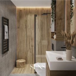 Sens Architekci - Nowoczesna łazienka z drewnianymi panelami, szklaną kabiną prysznicową z czarną ramą, grzejnikiem drabinkowym, białą umywalką nablatową i dekoracyjnymi suszonymi trawami w wazonie, uzupełniona...