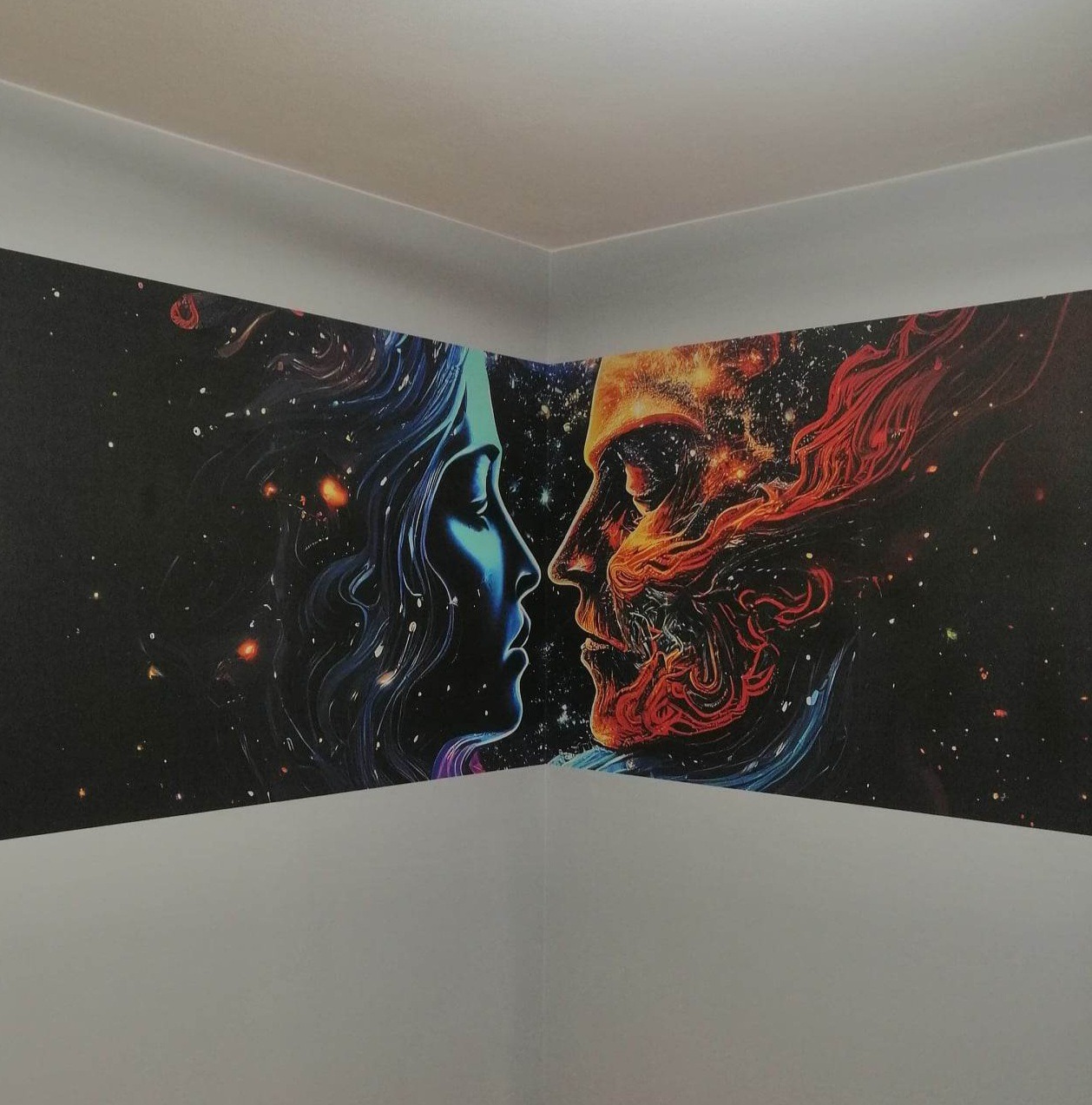 Abstrakcyjna tapeta w rogu pokoju przedstawiająca profil kobiety w odcieniach niebieskiego i mężczyzny w odcieniach czerwieni na tle kosmosu.