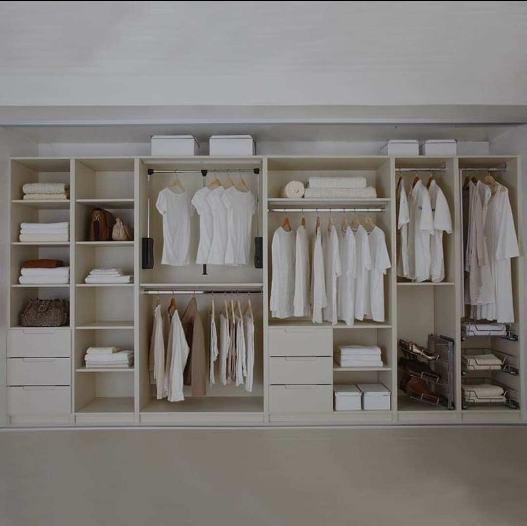 Jasna, przestronna garderoba z systemem półek, szuflad i drążków na ubrania, zrealizowana w Grodzisku Dolnym.